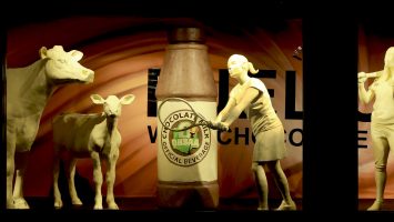 This year, the traditional butter cow and calf are accompanied by four young student-athletes and a larger-than-life bottle of the official beverage that fuels them, chocolate milk.